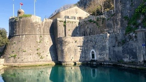 Forteresse bastionnée en pierre se reflétant dans des douves